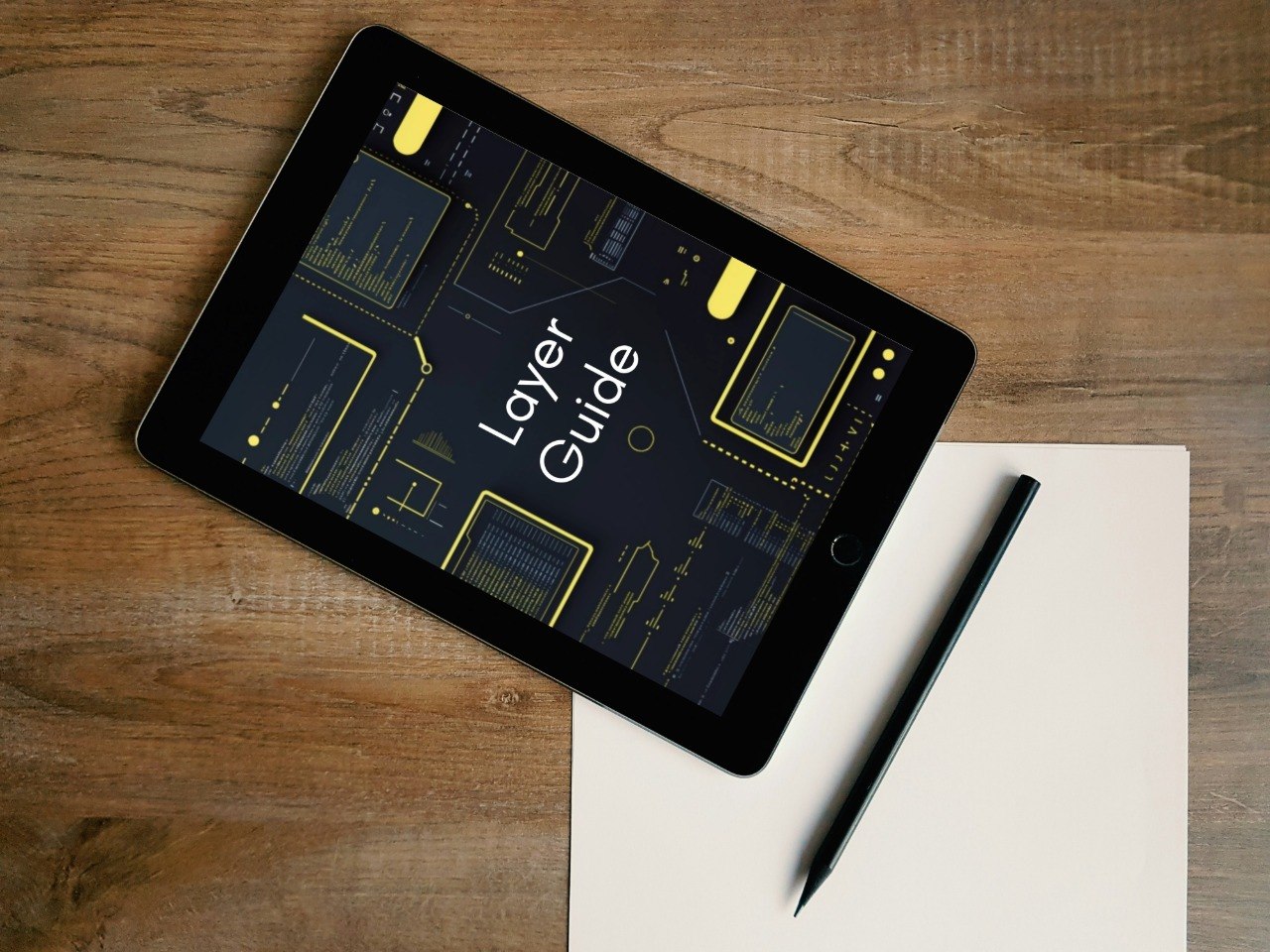 Tablet displaying 'Layer Guide' on a wooden surface with a pen