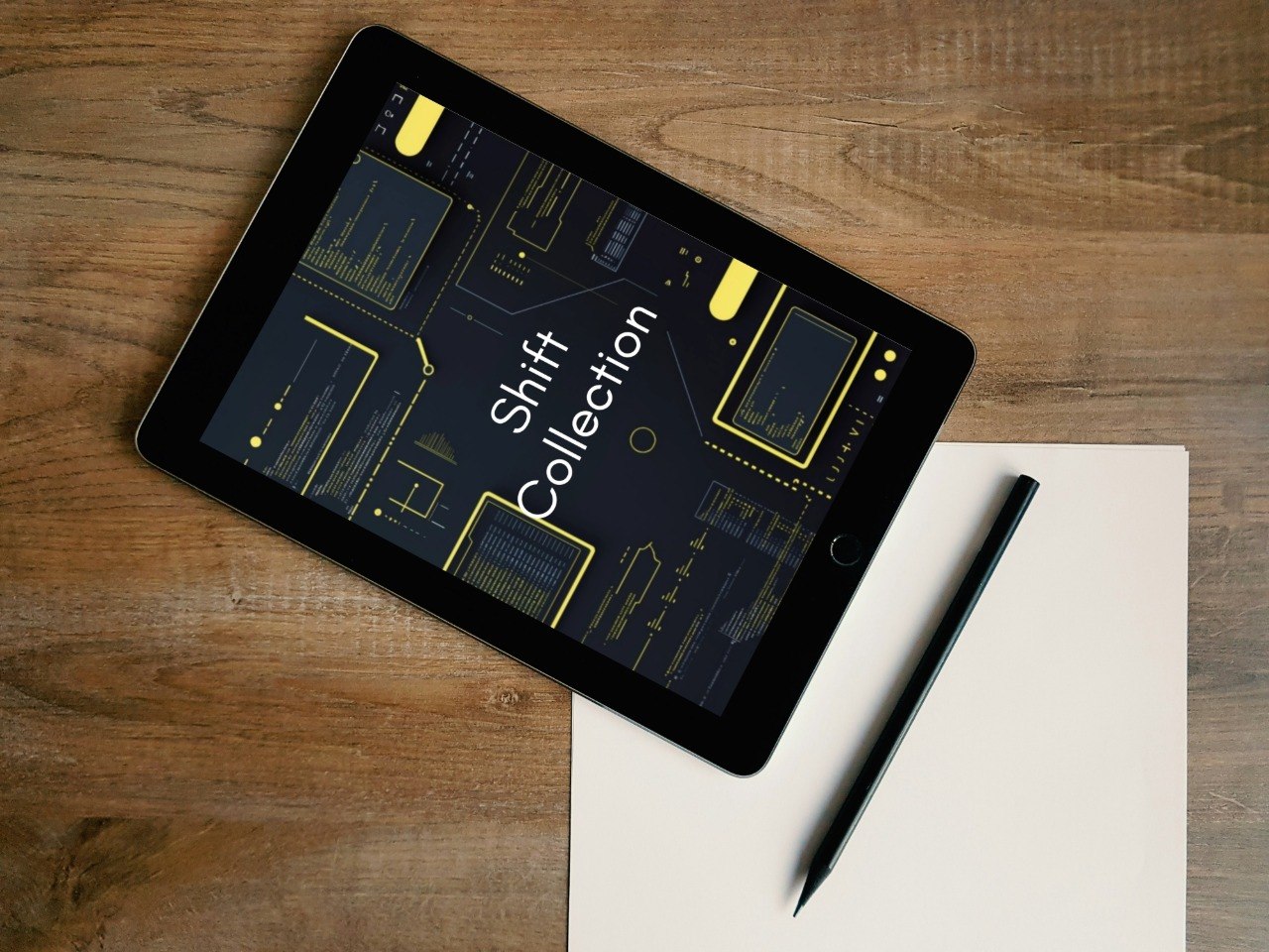 Tablet displaying 'Shift Collection' on a wooden surface with a pen